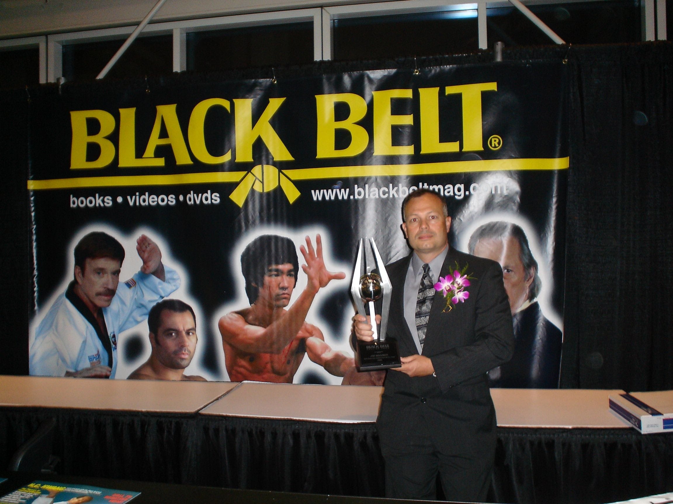In this photo Jim holds up his trophy awarded to him from Black Belt Magazine for Self-Defense Instructor of the Year 2006. He has received several such awards.