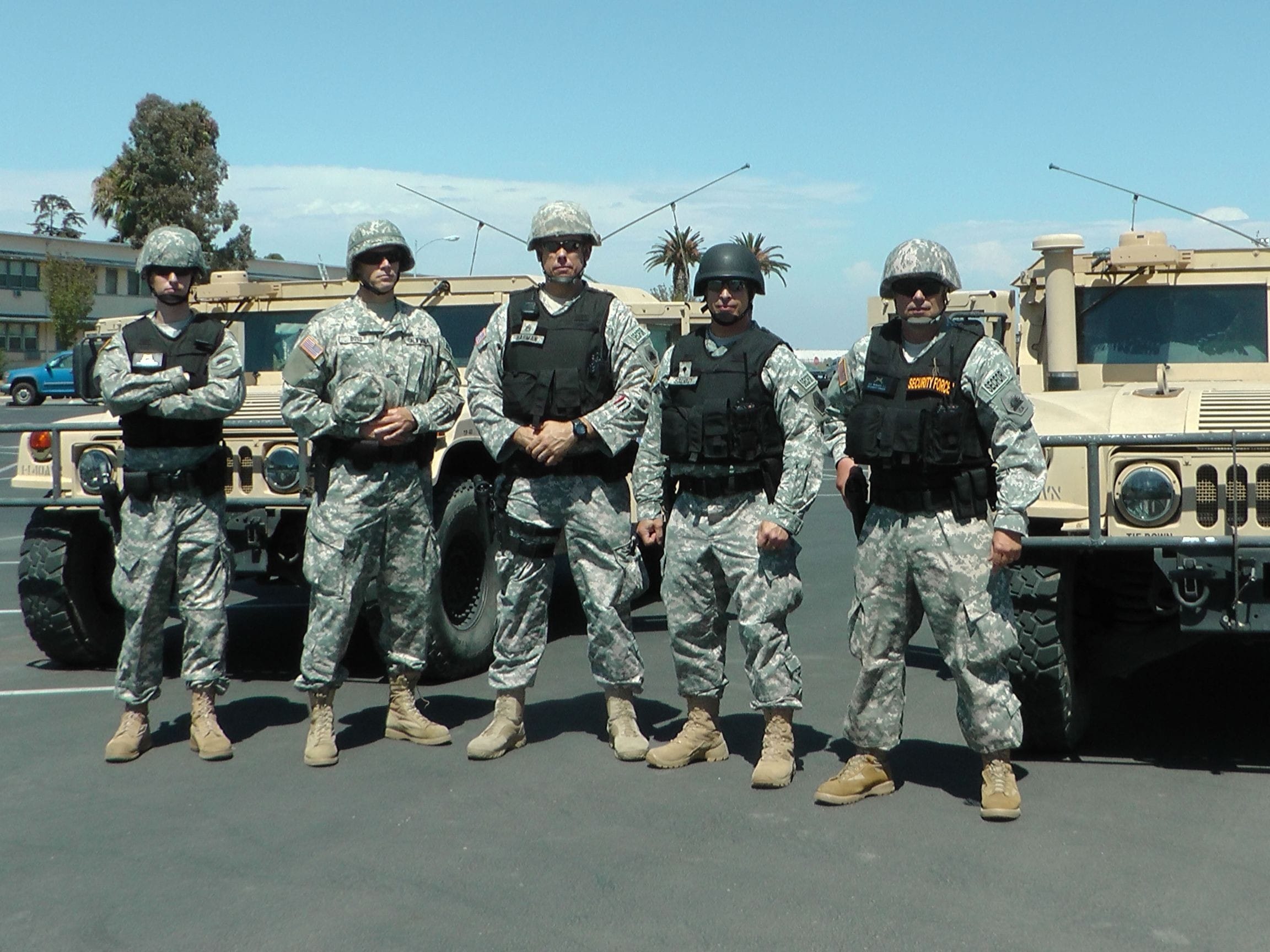 Sergeant First Class Wagner (far right) with a few of his SRT soldiers standing in front of two armored Humvees.